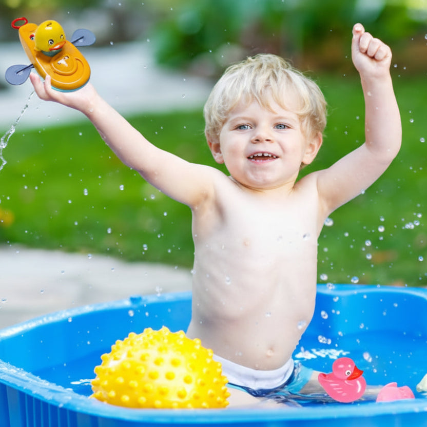 jouet de baignoire bébé garçonnet pataugeoire avec canard kayak dans main